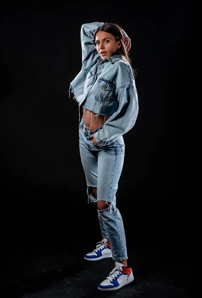 穿着蓝色斜纹棉裤和裁剪牛仔夹克的时髦年轻女人 — 图库照片