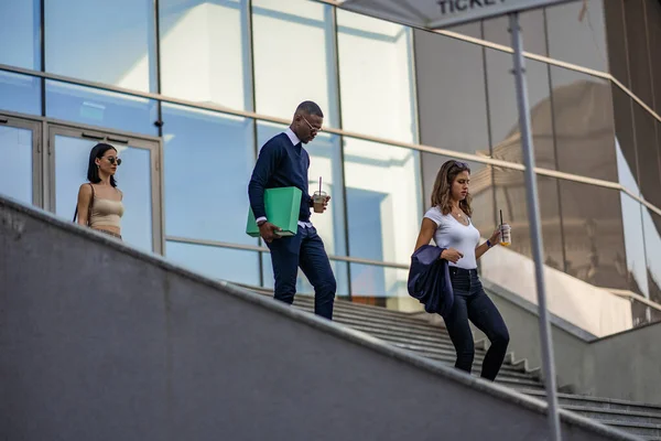 Drei Multiethnische Und Junge Mitarbeiter Gehen Gemeinsam Die Treppe Hinunter — Stockfoto