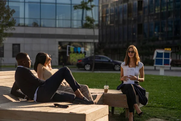 Three Multiracial Business People Smiling Talking Meeting While Sitting Bench — Stockfoto