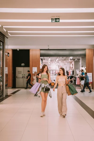 Twee Mooie Meisjes Met Boodschappentassen Die Door Het Winkelcentrum Lopen — Stockfoto