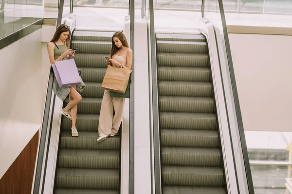 Two Beautiful Girls Looking Phones While Going Escalator Mall — Stok fotoğraf