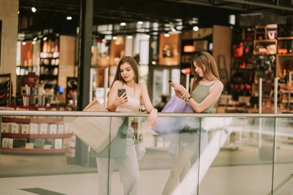 Meninas Bonitos Apoiando Cerca Shopping Enquanto Olha Para Seus Telefones — Fotografia de Stock