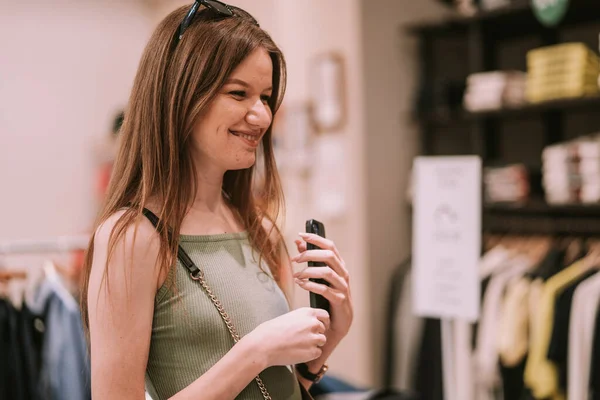 Pretty Girl Mens Shop Standing Her Phone Her Hands Smiling — Fotografia de Stock