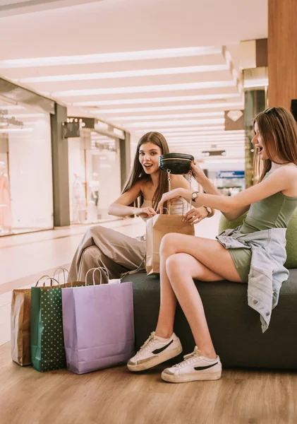 Two Pretty Best Friends Sitting Sofa Shopping Mall While Looking — ストック写真
