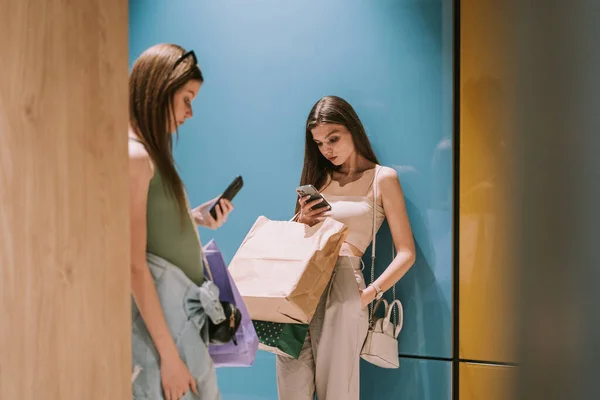 Two Cute Best Friends Looking Phones While Standing Hallway — 스톡 사진