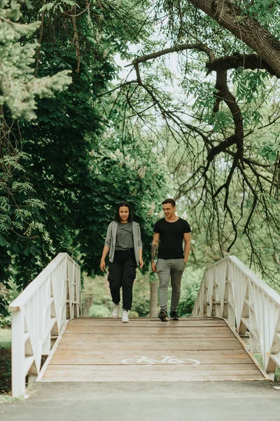Beautiful couple walking  on the bridge in the park