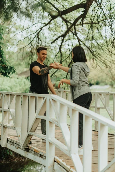 Cute Couple Shaking Hands Laughing While Standing White Bridge Park — Stockfoto