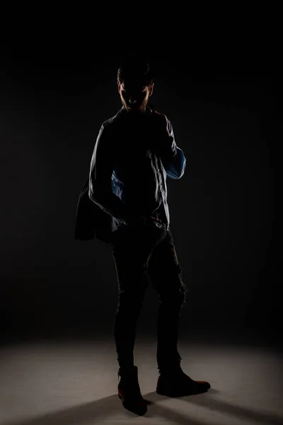 Tall and handsome male posing in the studio with dimmed lights