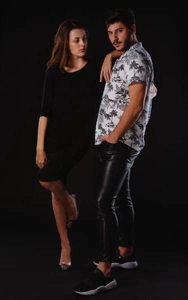 Body shot of attractive male and female models posing in modern clothes