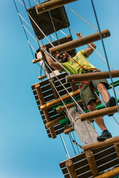 在冒险公园 一个运动员在高高的空中穿越木板 — 图库照片