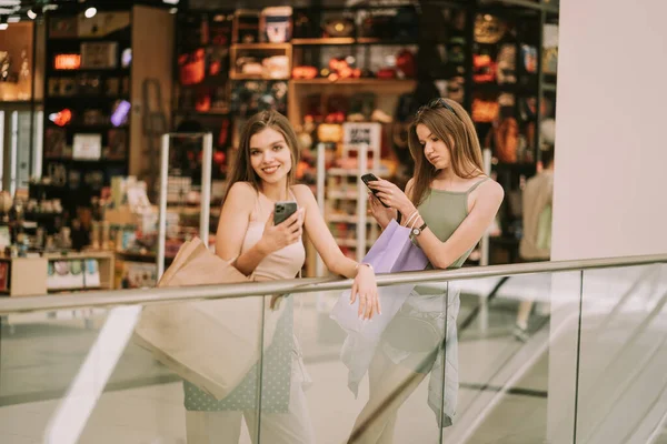 Chicas Guapas Apoyadas Cerca Del Centro Comercial Mientras Miran Sus —  Fotos de Stock