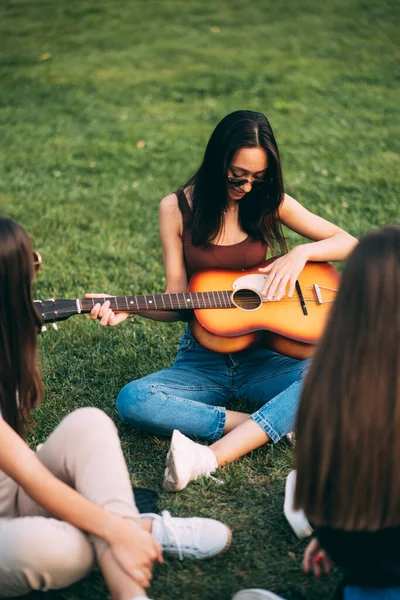 Magro Atraente Jovem Está Tocando Guitarra Enquanto Seus Amigos Estão — Fotografia de Stock