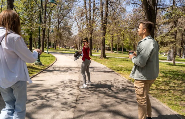 Full body happy women and man in casual outfits walking in summer park, outdoors