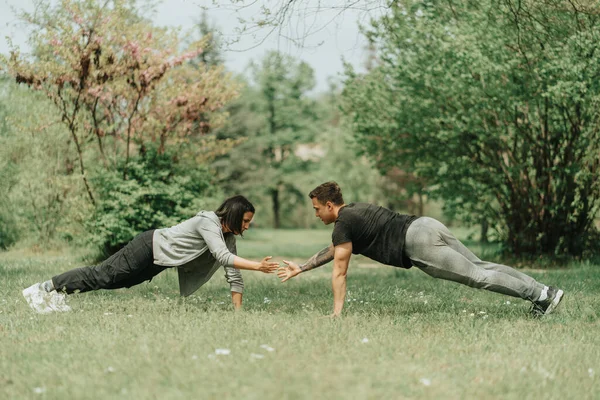 公園で草の上で働く美しいカップル — ストック写真