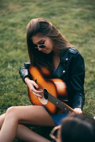 Attraktiv Och Vacker Tjej Spelar Gitarr Medan Hon Sitter Gräset — Stockfoto