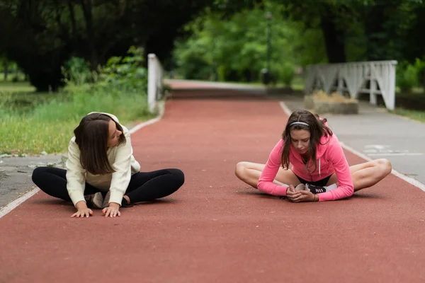 Két Vonzó Fiatal Lány Barátok Beszélnek Képzés Miközben Nyújtózkodik — Stock Fotó