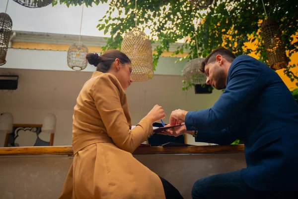 一位有魅力的女商人正在帮她的男朋友做日常事务 而她们则在户外的咖啡吧里一起工作 — 图库照片