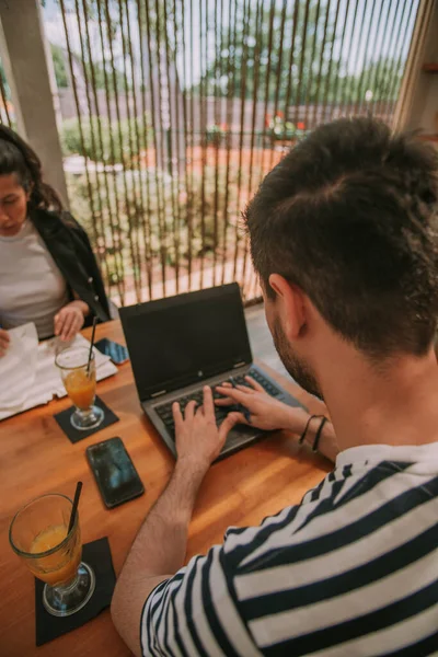 Geschäftsmann Tippt Computer Während Mit Seiner Partnerin Café Sitzt — Stockfoto