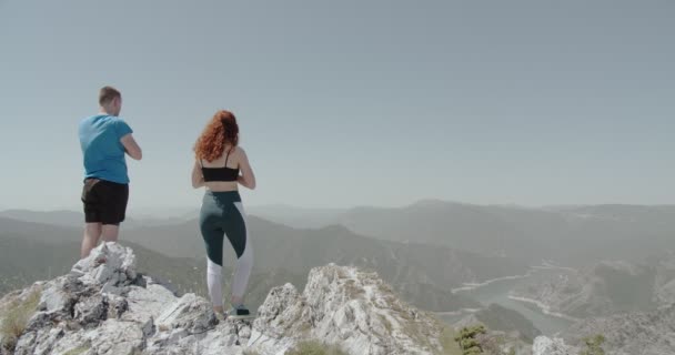世界の頂上でヨガをするカップル 高い山の景色 — ストック動画