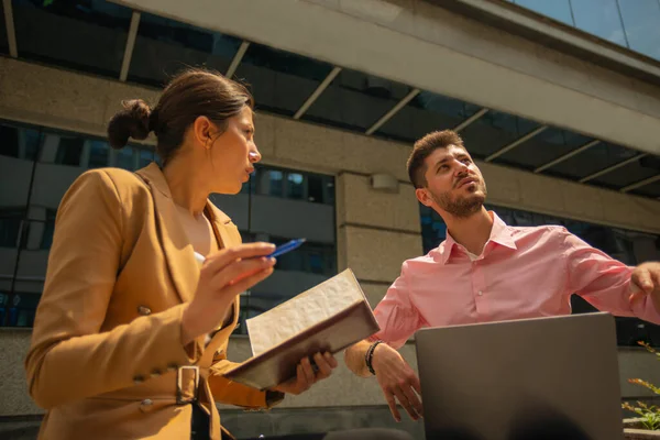 A young talented business people are working outside in the city, on a sunny day