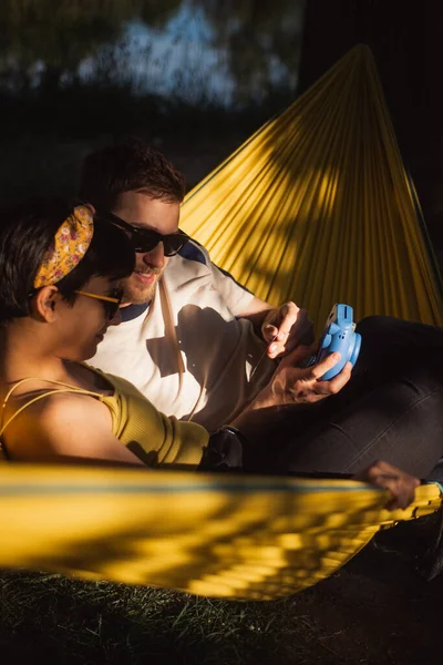 Casal Bonito Olhando Para Câmera Enquanto Sentado Uma Rede Amarela — Fotografia de Stock