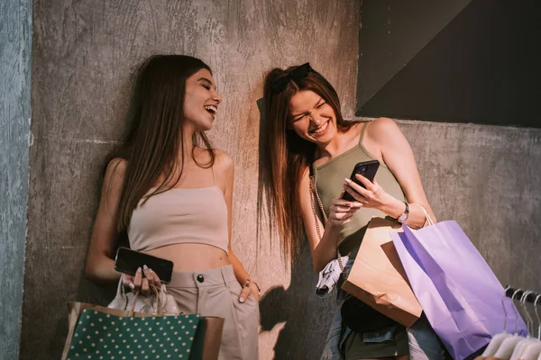 Two Young Beautiful Sisters Laughing Phone Whilst Holding Bags Clothes — ストック写真