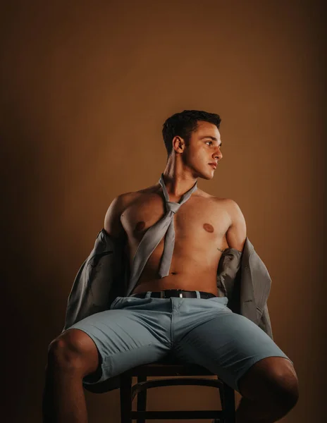 Hermoso Modelo Masculino Posando Silla Estudio Mientras Está Sentado — Foto de Stock