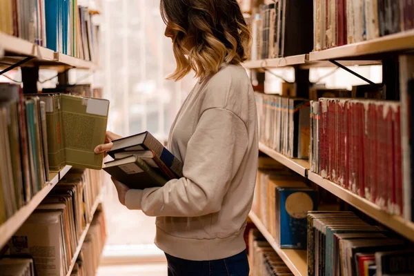 Mädchen Wählt Ein Buch Aus Dem Bücherregal Der Bibliothek — Stockfoto