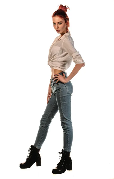 トレンディーなデニムパンツやブラックブーツに身を包んだ美しい女性モデルの肖像 — ストック写真