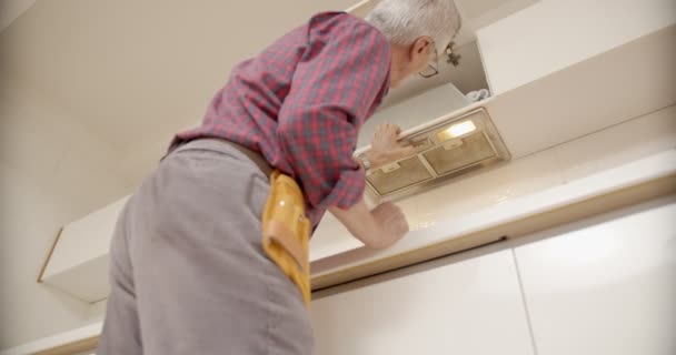 Handyman Met Een Gereedschapsriem Voor Ventilatieopeningen Keuken — Stockvideo