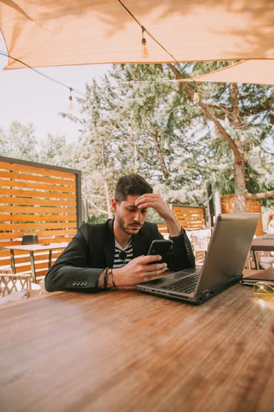 Hombre Negocios Guapo Mirando Teléfono Mientras Está Sentado Mesa Del — Foto de Stock