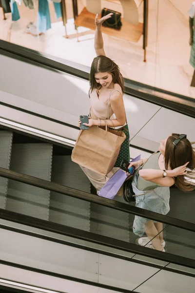 Duas Garotas Bonitas Com Sacos Compras Subindo Escada Rolante Divertindo — Fotografia de Stock