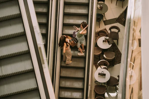 Zwei Hübsche Teenager Mädchen Steigen Auf Die Rolltreppe Während Sie — Stockfoto