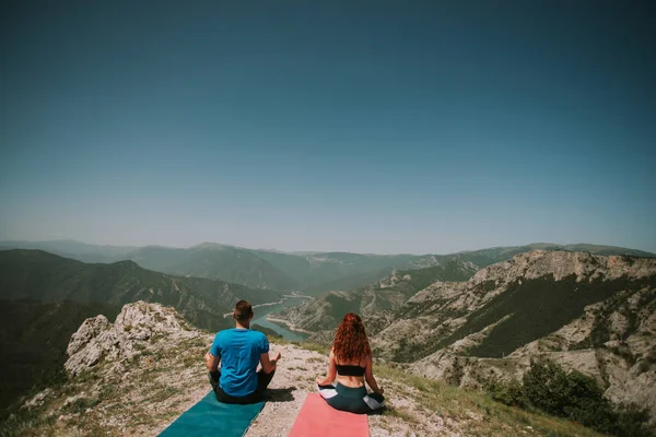 瑜伽夫妇坐在瑜伽垫上 在山顶上放松一下 — 图库照片