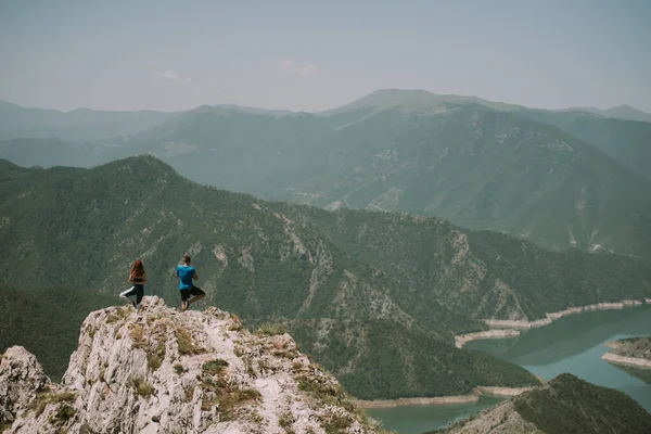 瑜伽夫妇在山顶上做瑜伽姿势 双腿向上 — 图库照片