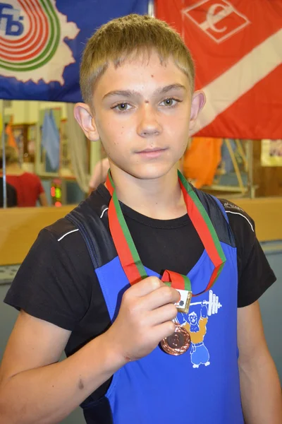 First medal of the young weight-lifter — Stock Photo, Image