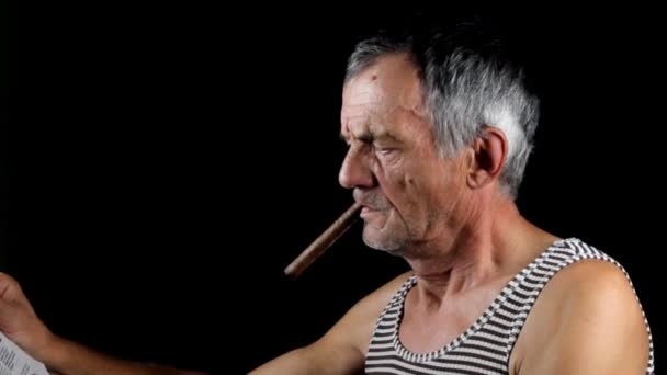 Man smokes cigar and read newspaper — Stock Video