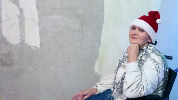 Äldre kvinna med santa hatt i rullstol — Stockvideo