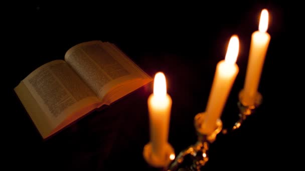 Канделябры со свечами и книгой — стоковое видео