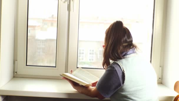 Een vrouw die een boek leest — Stockvideo