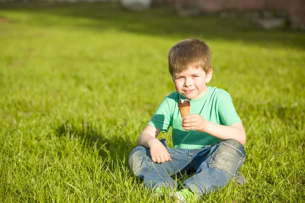 Niño en el parque comiendo helado — Foto de Stock