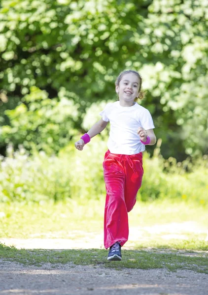 Liten flicka kör i park — Stockfoto