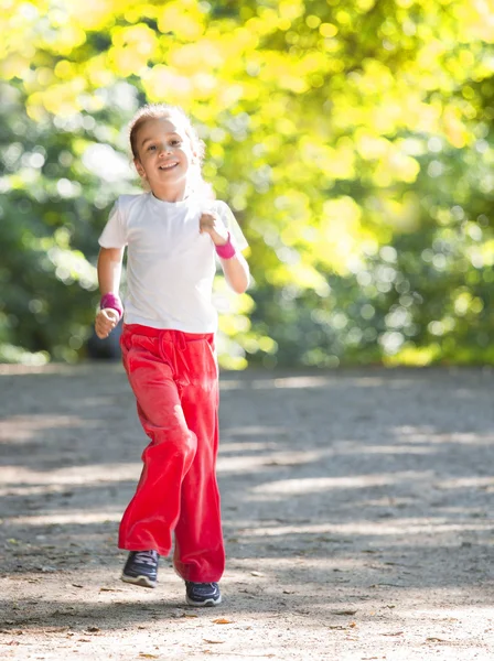 Kleines Mädchen läuft in Park — Stockfoto