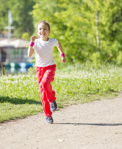 Маленька дівчинка біжить в парку Стокова Картинка