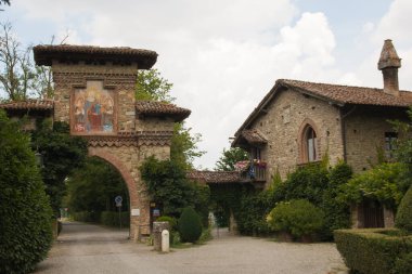 GRAZZANO VISCONTI, İtalya - 18 Temmuz 2021: Emilia-Romagna yaz günü Grazzano-Visconti kale parkının güzel kemerli girişi