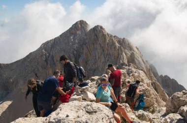 CORNO GRANDE, ITALY - AUGUST 6, 2022: Panoramic view of the summit of Corno Grande in the Gran Sasso d'Italia massif during summer day of august with hikers