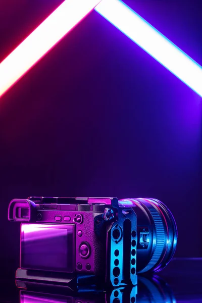 プロのビデオカメラマン装置 ケージにレンズ付きデジタルカメラ 黒いテーブルの背景の正面図 — ストック写真