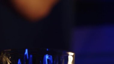 lcohol is poured into a bar glass from a chilled bottle. Close-up, bokeh, rotated subject
