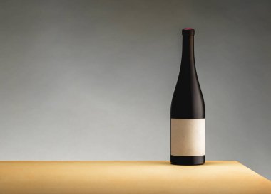 Gri arka plandaki sarı masada bir şişe şarap. Minimalizm kavramı. Reklam afişi. Metin için yer