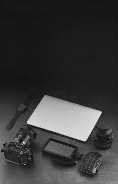 暗い背景にワークスペースのモックアップテンプレート カメラ ノートパソコン 再生モニター メモリカードホルダーとレンズとビデオカメラの職場 — ストック写真